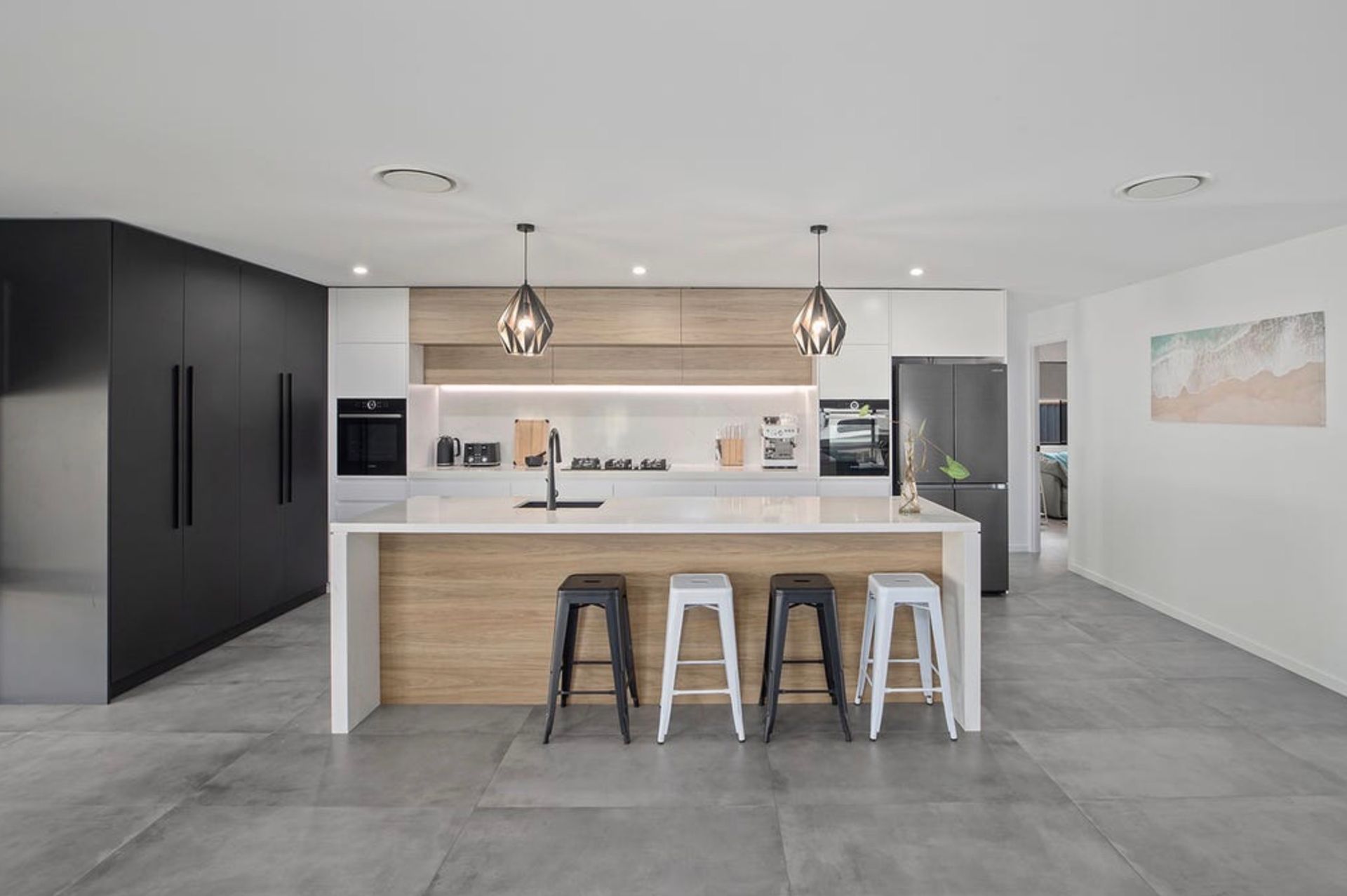 Modern kitchen with island, black and wood cabinets, stainless steel appliances — Platinum Kitchens & Bathrooms in North Boambee Valley, NSW