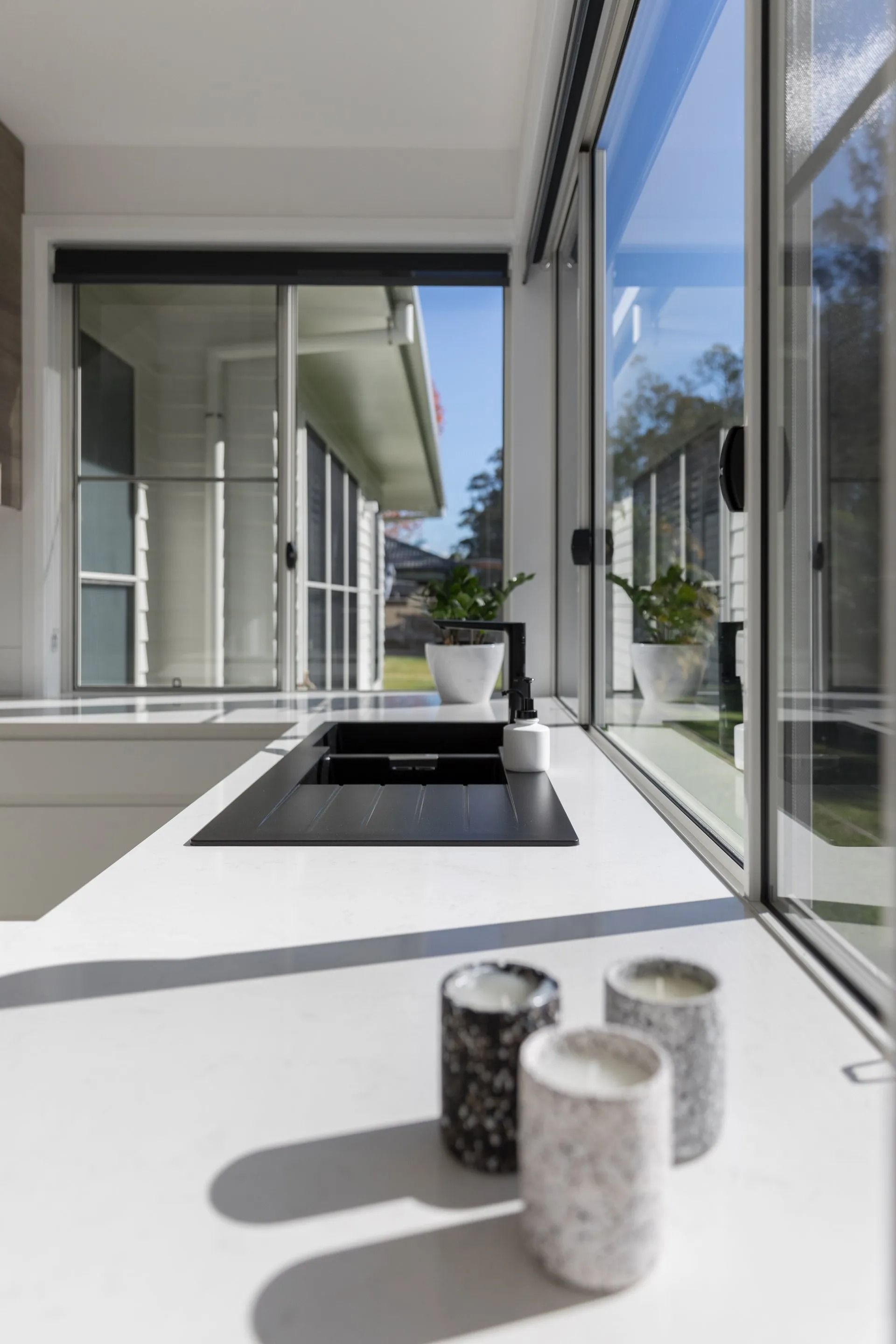 Modern Kitchen Counter with Three Decorative Candles — Platinum Kitchens & Bathrooms in North Boambee Valley, NSW