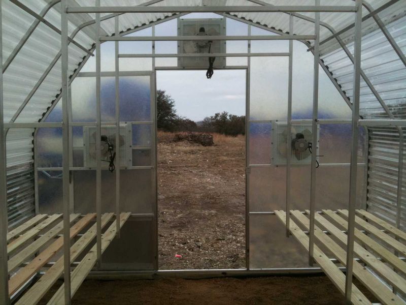 A greenhouse with a fan hanging from the ceiling.
