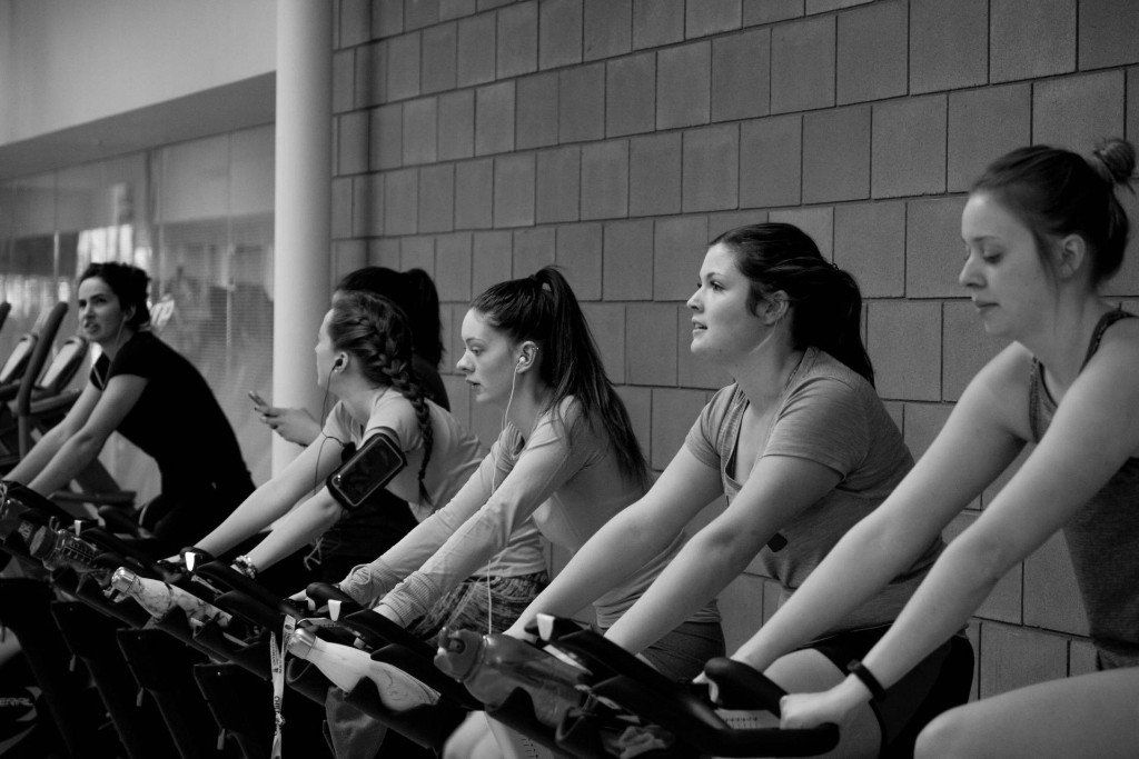 Een groep vrouwen rijdt op hometrainers in een sportschool.