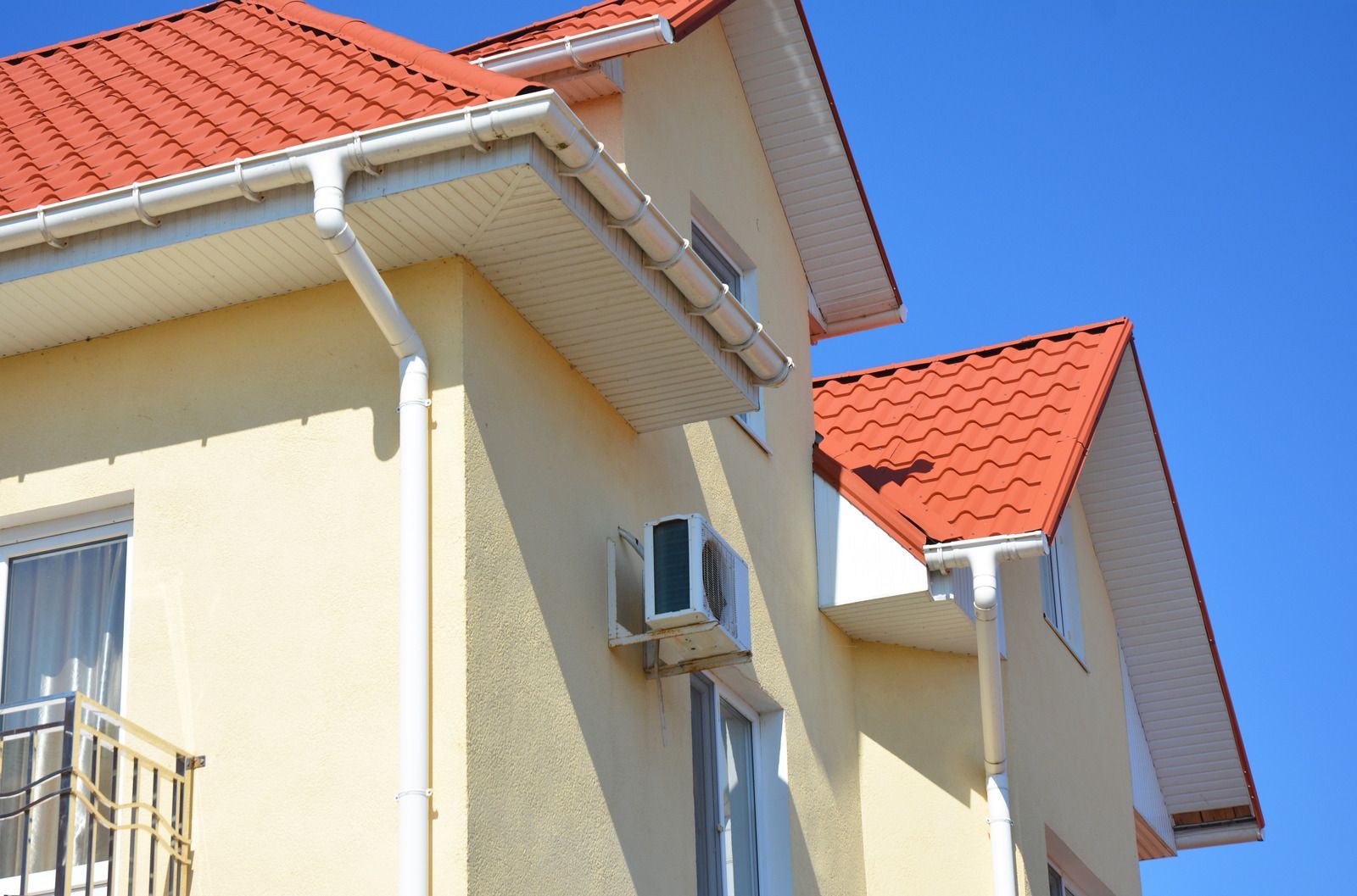 A house with a red roof and a white gutter