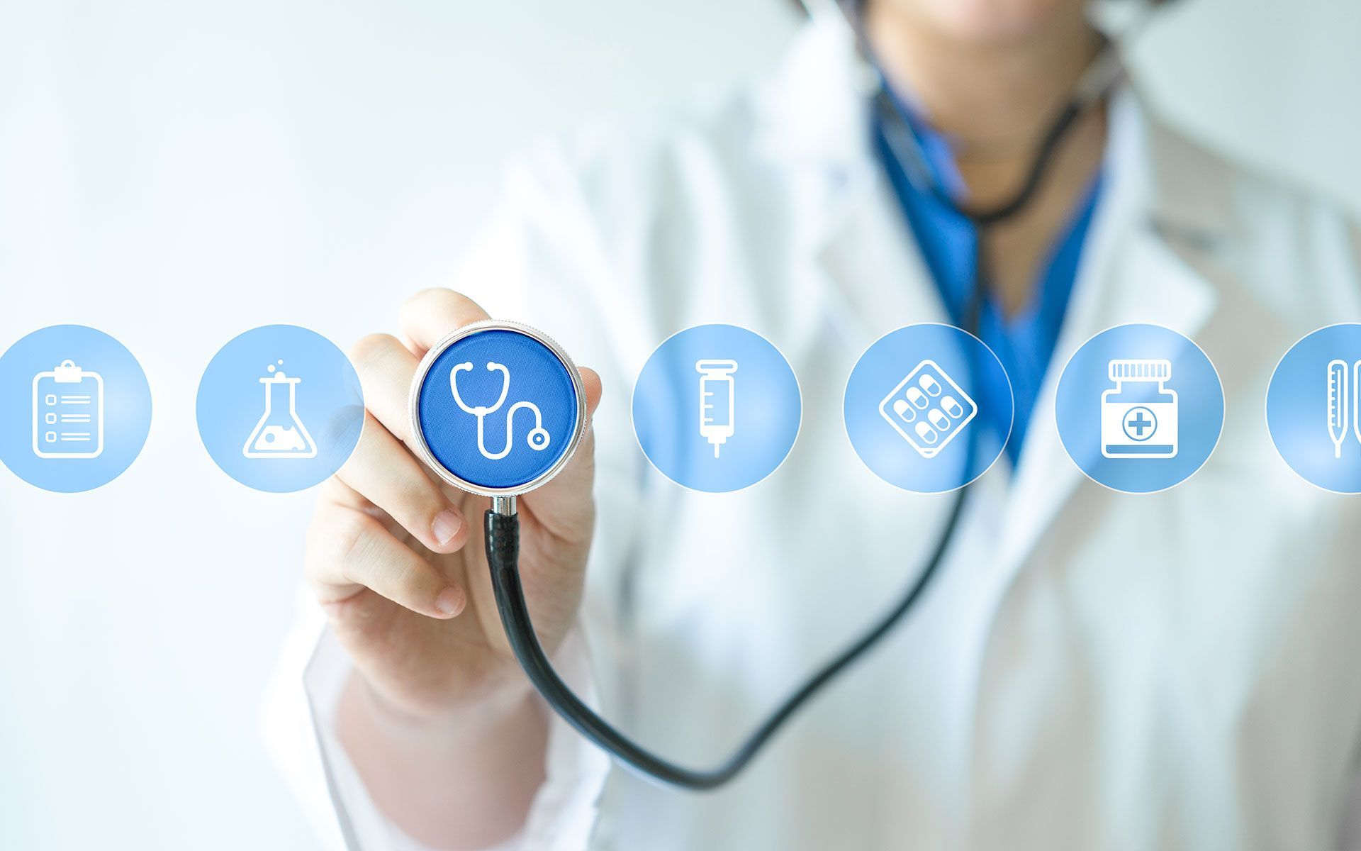Doctor holding stethoscope towards medical icons.