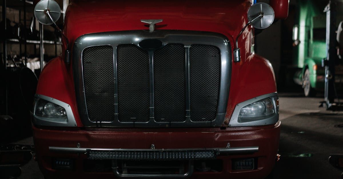 A red semi truck is parked in a dark garage.