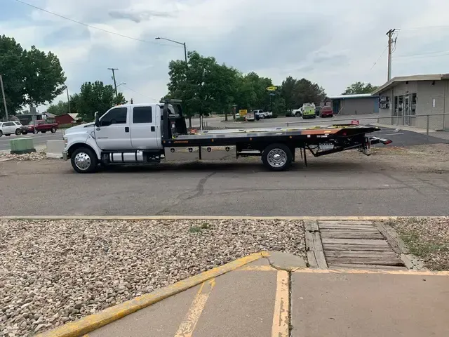 A tow truck is parked on the side of the road.
