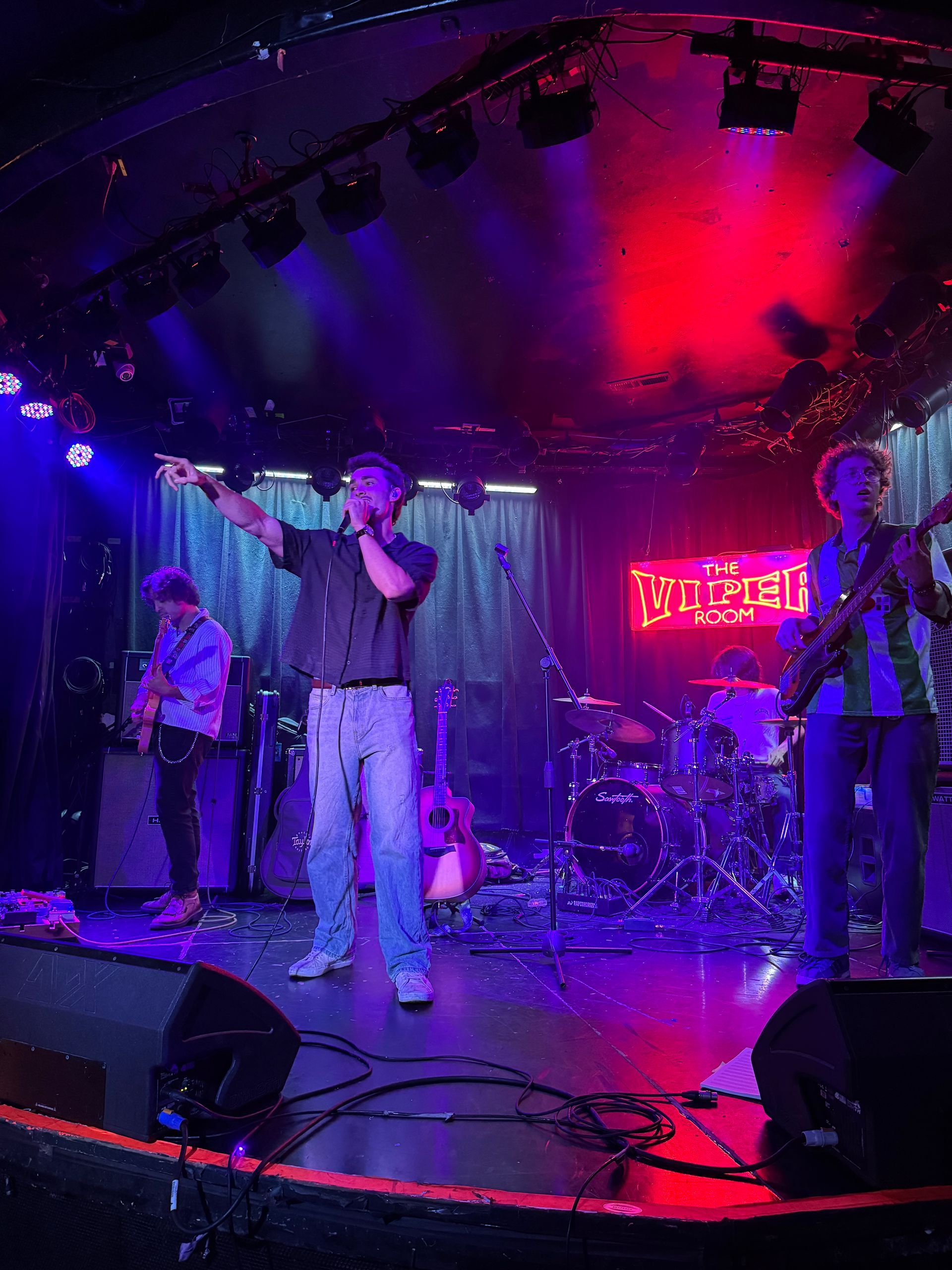 A microphone is sitting on a stand in front of a blue light.