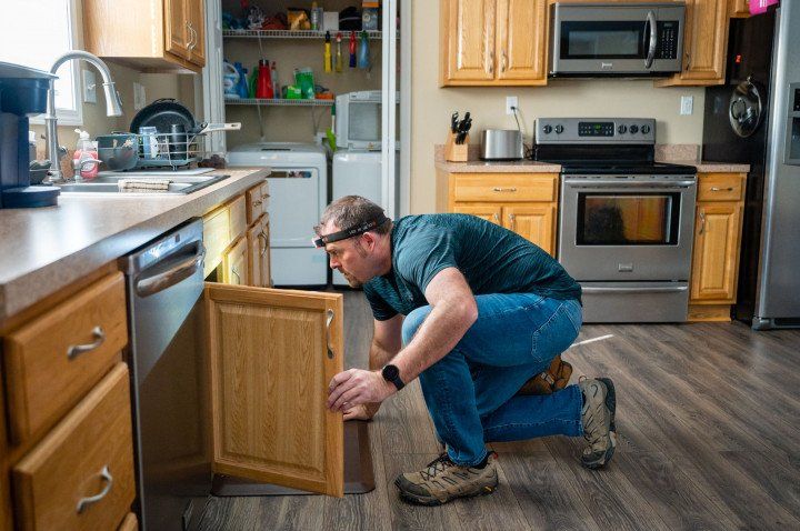 Man Checking The Cabinet In The Kitchen
