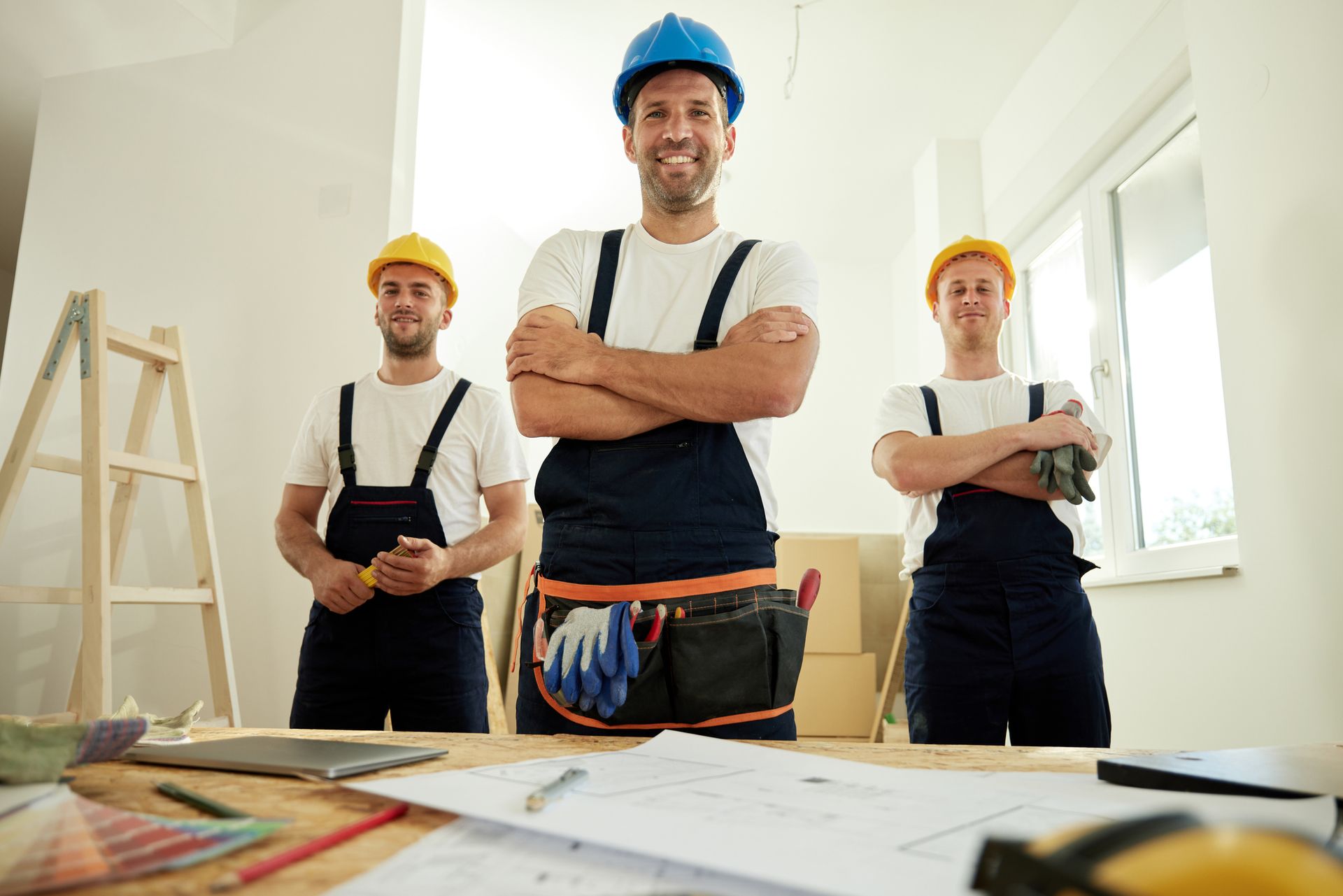 Un operaio edile tiene in mano un martello e un casco.