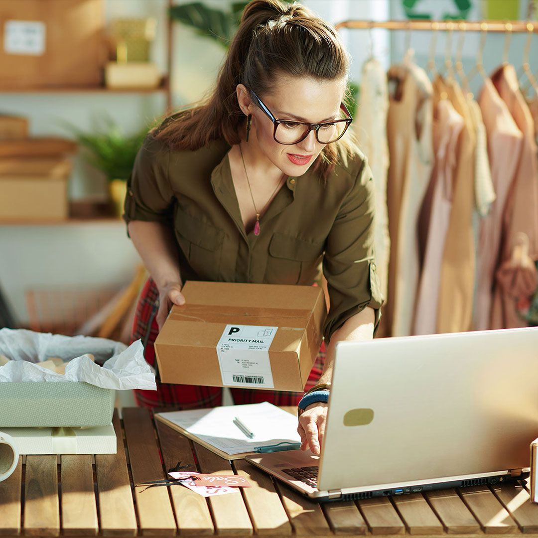 stylish small business owner woman using laptop in office