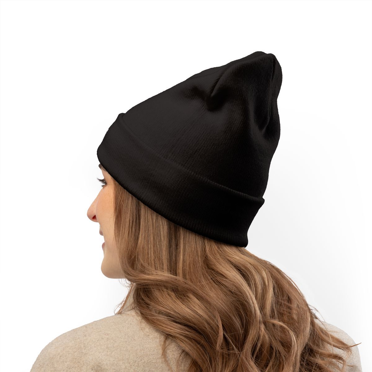 Woman wearing a black beanie, looking away, against a white backdrop.