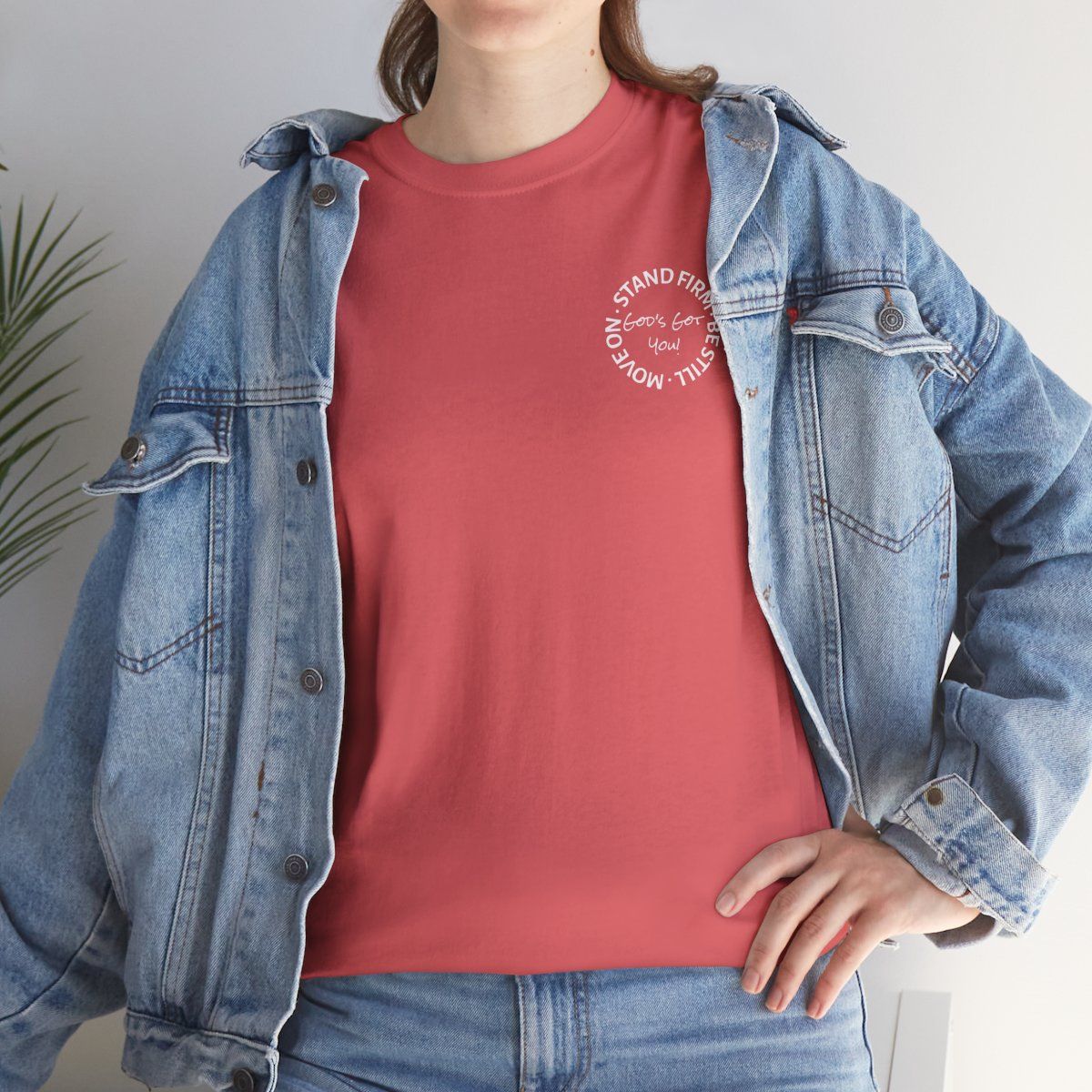 Woman wearing a red t-shirt under a denim jacket, with a circular graphic on the shirt.