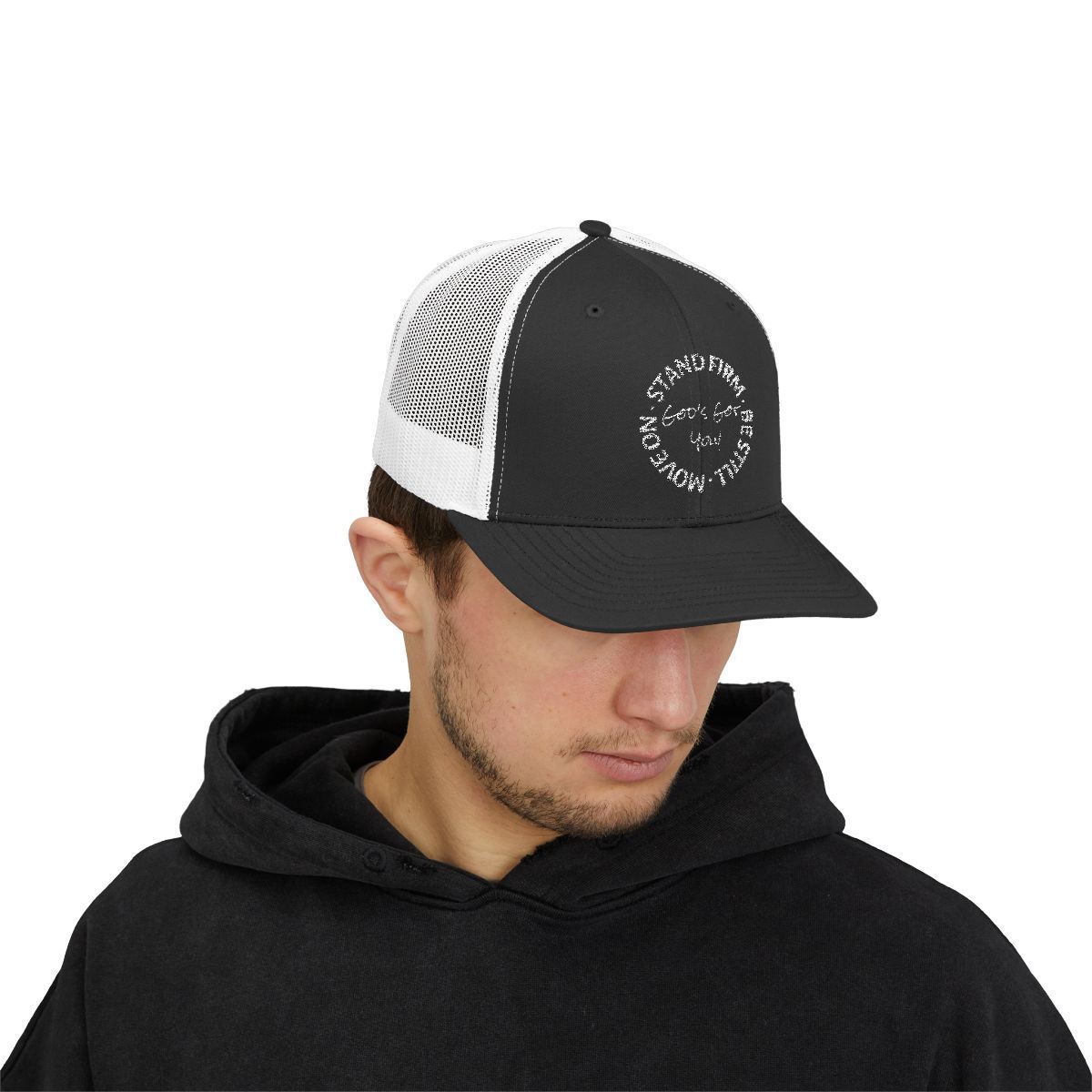 Man wearing a black hat with a white mesh back and text on the front. He's also wearing a black hoodie.