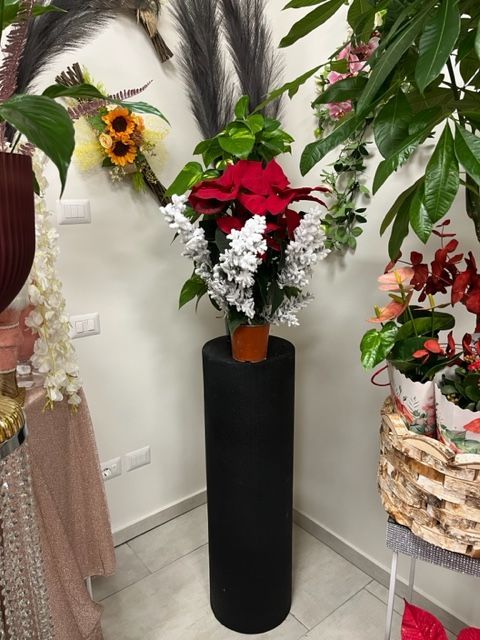 un vaso pieno di fiori appoggiato su un tavolo nero