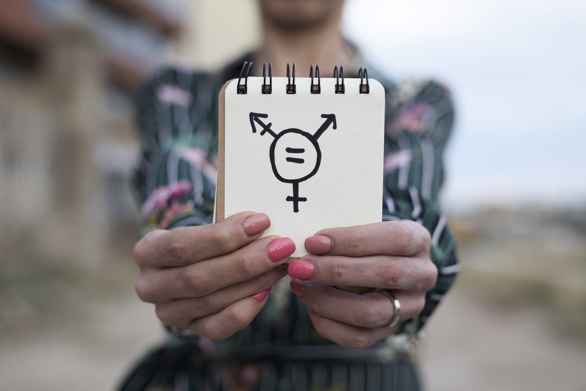 Woman shows notepad with a transgender equality symbol.