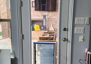 Interior view through an open door with dog door installed. Exterior patio in background.