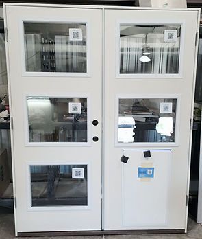 White double doors with four glass panels each, interior visible through the panes, some with QR codes.