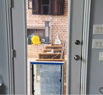 Open door with doggy door; brick patio visible.