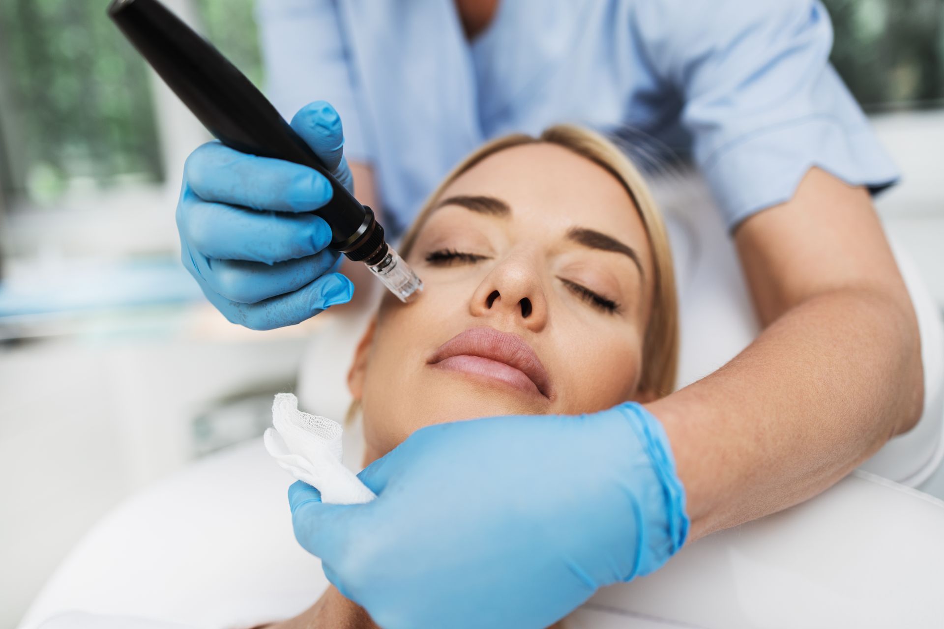 A woman is getting a microdermabrasion treatment on her face.