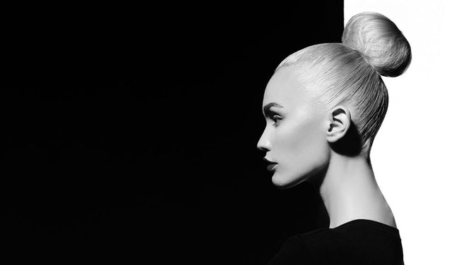 a black and white photo of a woman with a bun in her hair .