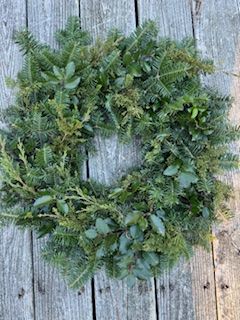 A wreath is sitting on top of a wooden table.