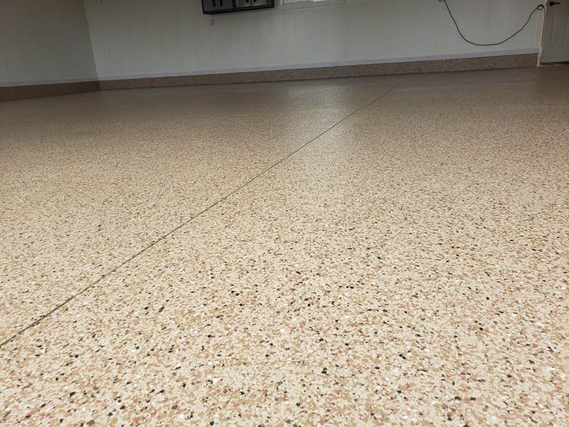 A close up of a beige floor with a white wall in the background.