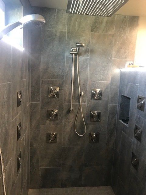 A shower with a shower head and a hose in a bathroom.