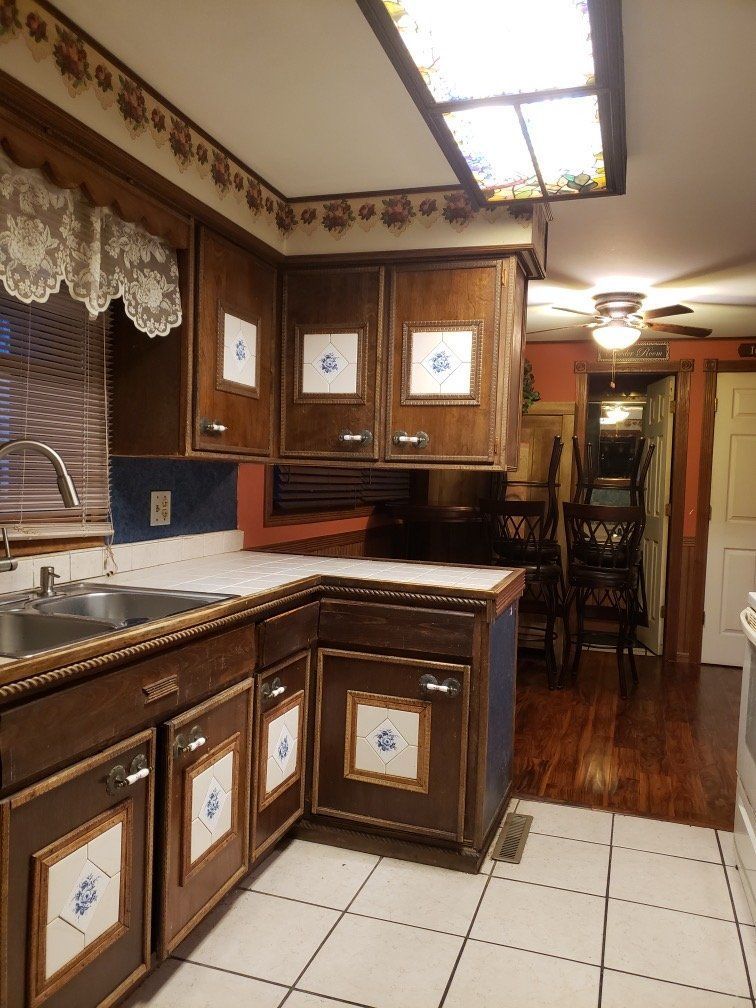 A kitchen with wooden cabinets , a sink , and a window.