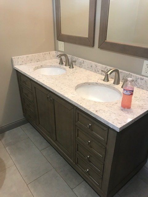 A bathroom vanity with two sinks and two mirrors.
