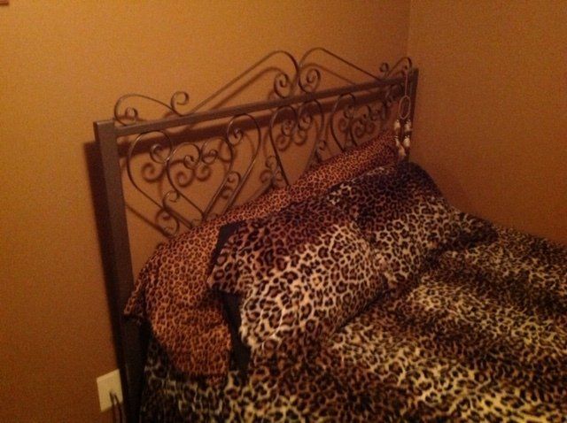 A bed with a leopard print comforter and pillows