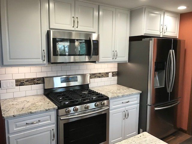 A kitchen with white cabinets and stainless steel appliances