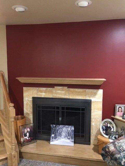 A living room with a fireplace and red walls