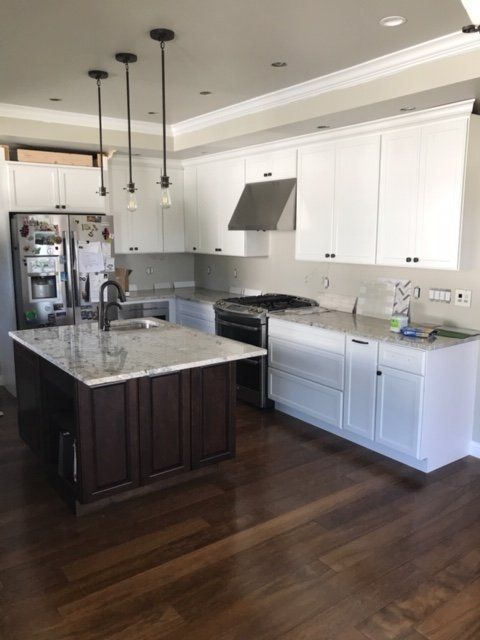 A kitchen with white cabinets and stainless steel appliances