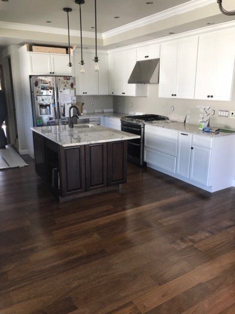 A kitchen with white cabinets and a large island