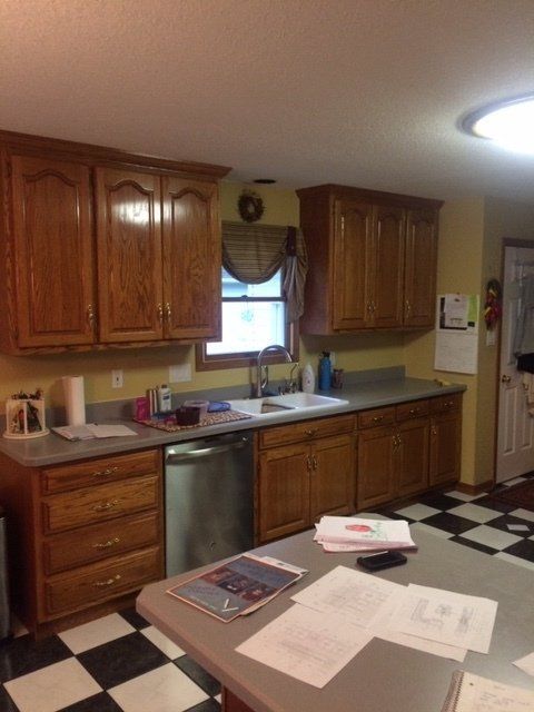 A kitchen with wooden cabinets and a checkered floor