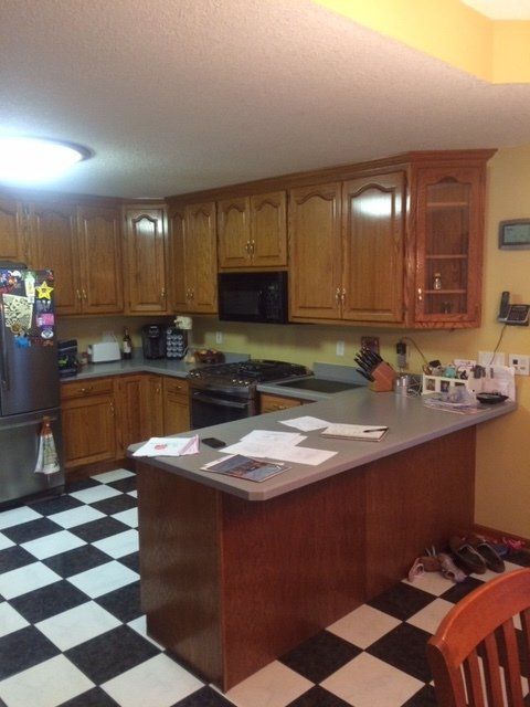 A kitchen with wooden cabinets and a checkered floor