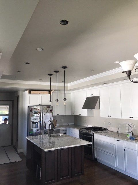 A kitchen with white cabinets and a large island