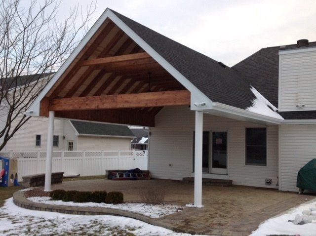 A white house with a covered patio in the backyard