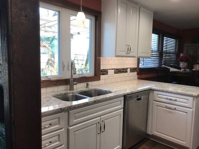 A kitchen with white cabinets and stainless steel appliances