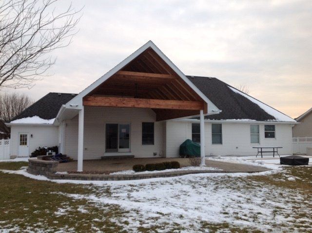 A white house with a covered patio in the backyard