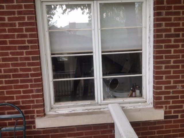 A window on a brick building with a white frame