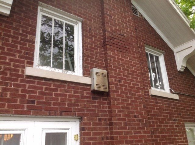 A red brick house with white windows and a white door.