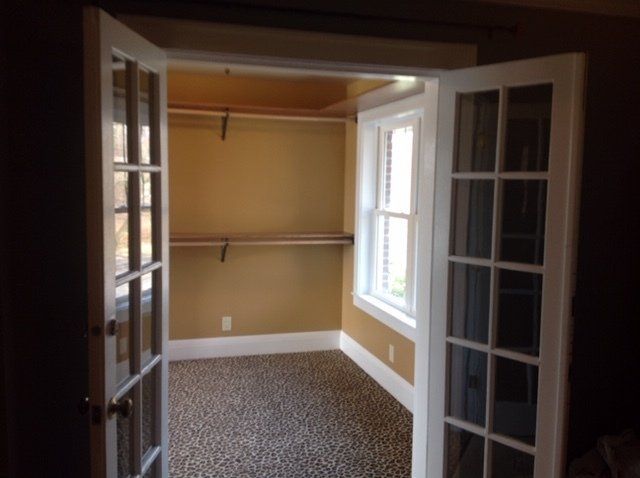 An empty room with french doors and a window