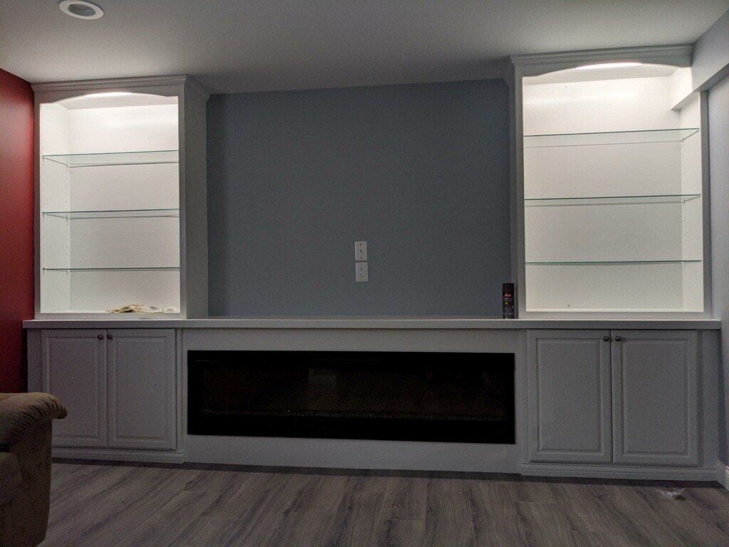 A living room with a fireplace and shelves