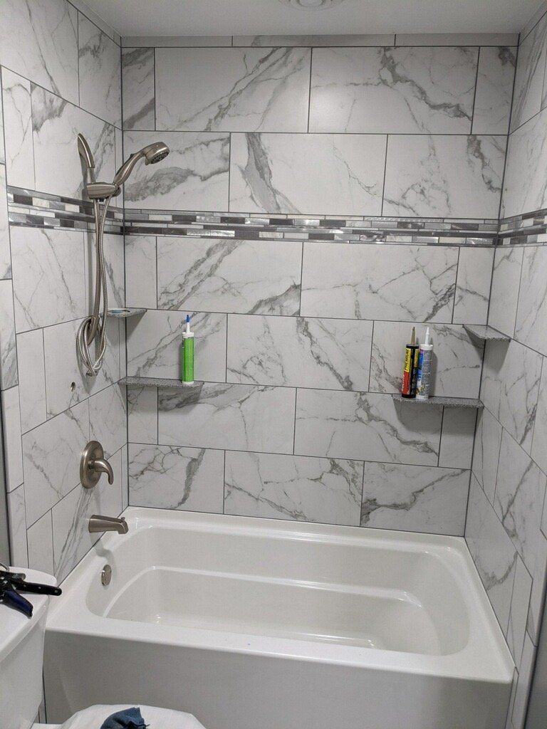 A bathroom with a bathtub , toilet and shower.