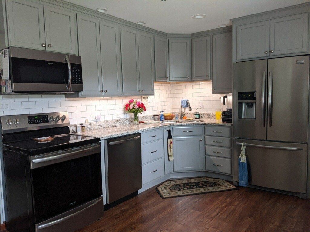 A kitchen with stainless steel appliances and gray cabinets