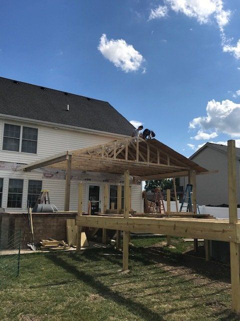 A wooden deck is being built in front of a house.