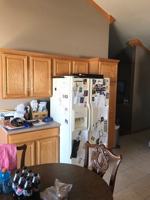 A kitchen with a table and chairs and a refrigerator