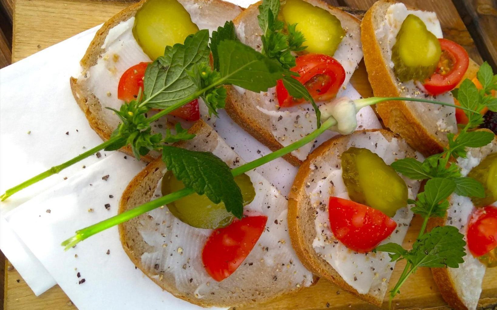 Blick auf geschmierte Fettschnitten, hübsch dekoriert mit Gurke, Paprika und Kräutern