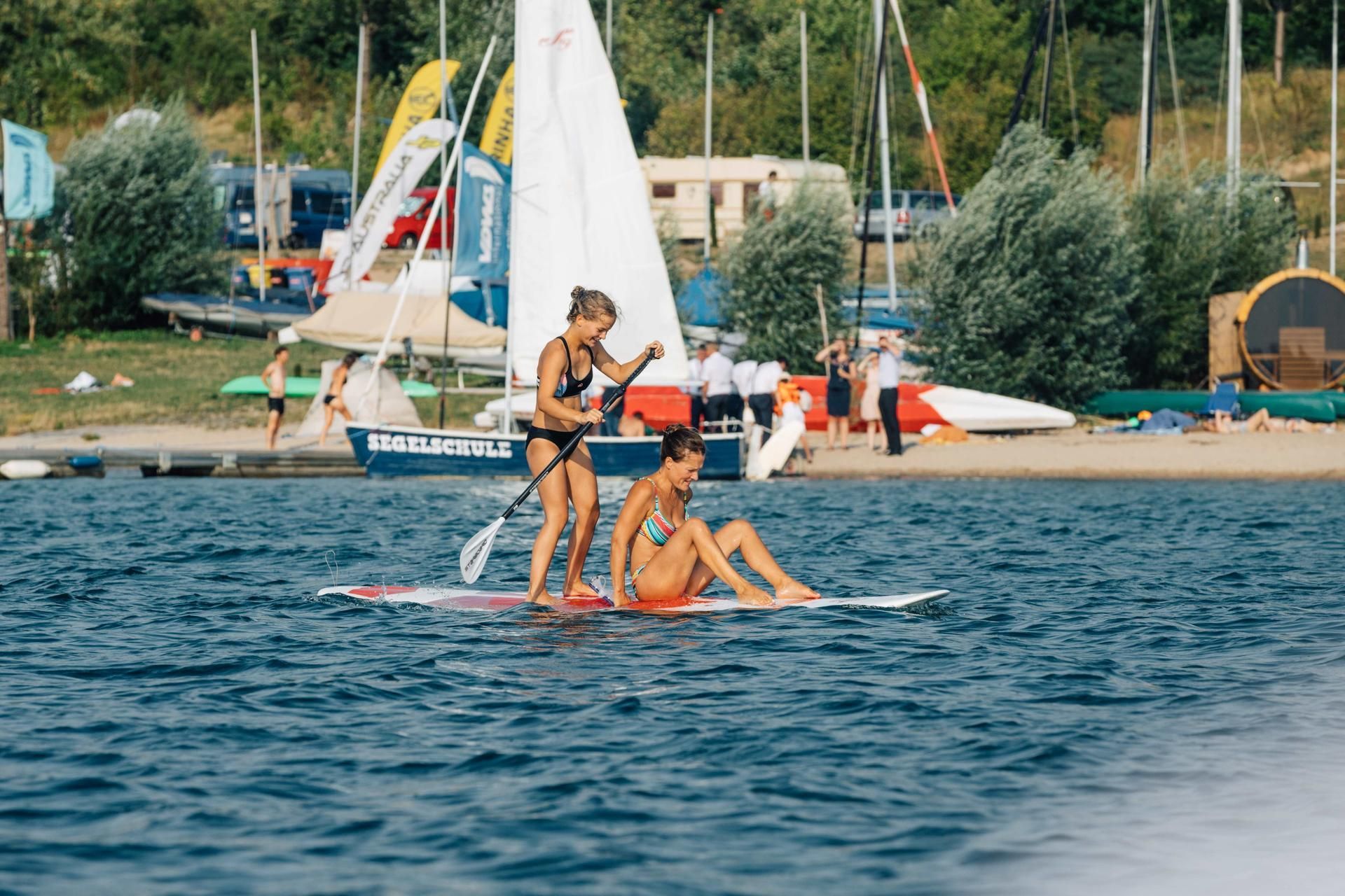 2 Stand-up-Paddlerinnen auf einem See unterwegs