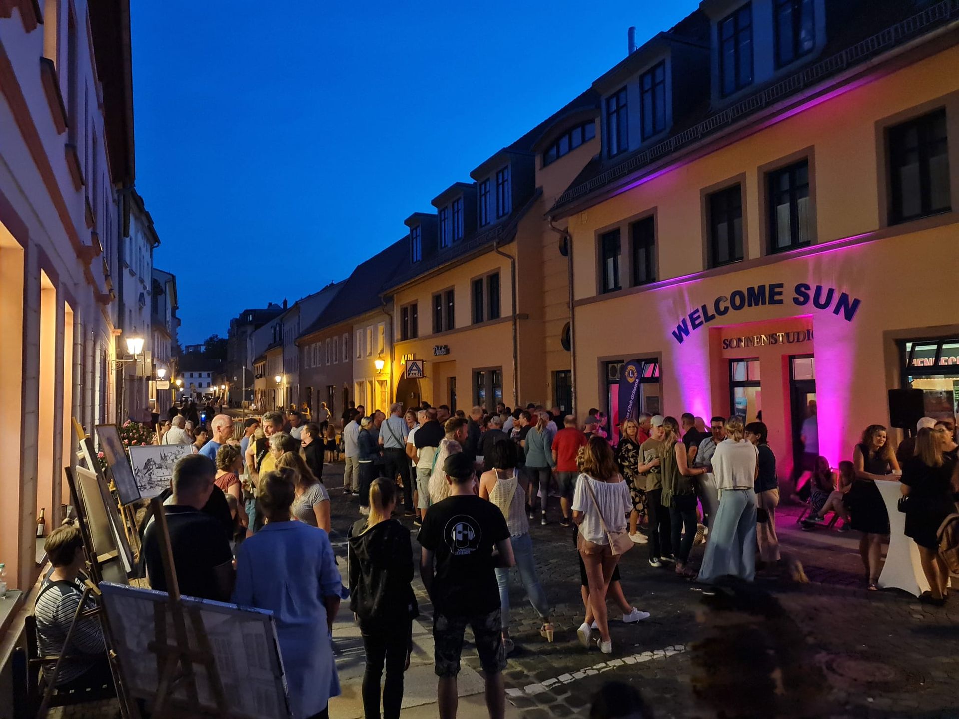 Die Lange Straße in Grimma bei Nacht mit einer Veranstaltung und vielen Menschen
