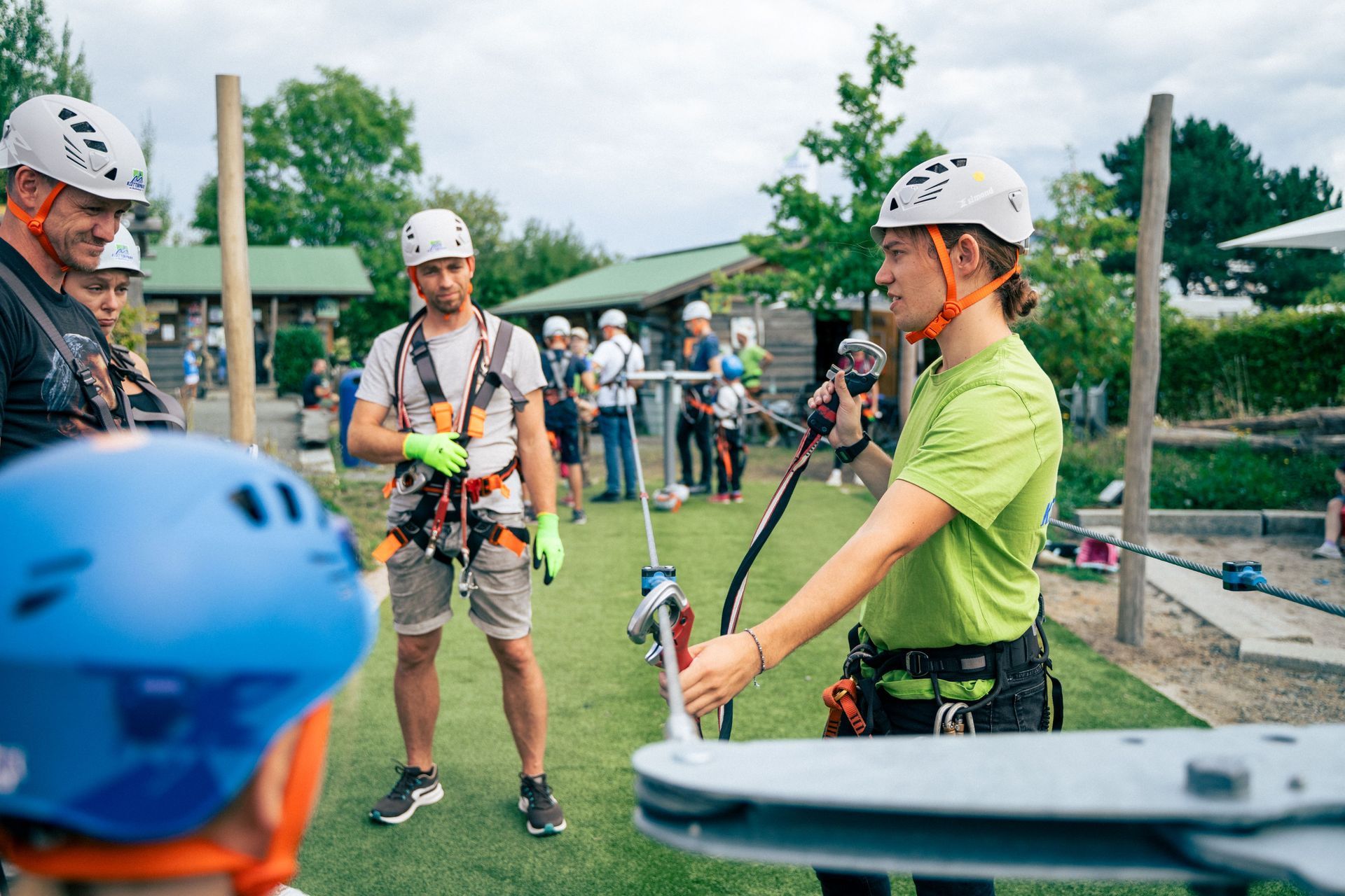junge Guides zeigen das Anhaken mit dem Klettergeschirr